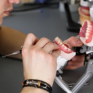 a lab technician working on creating dentures