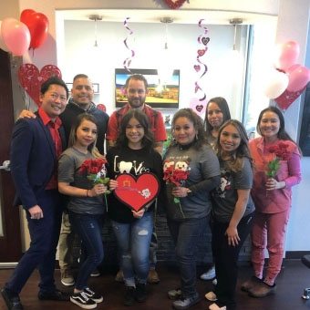 Group of team members and patients at dental office reception desk