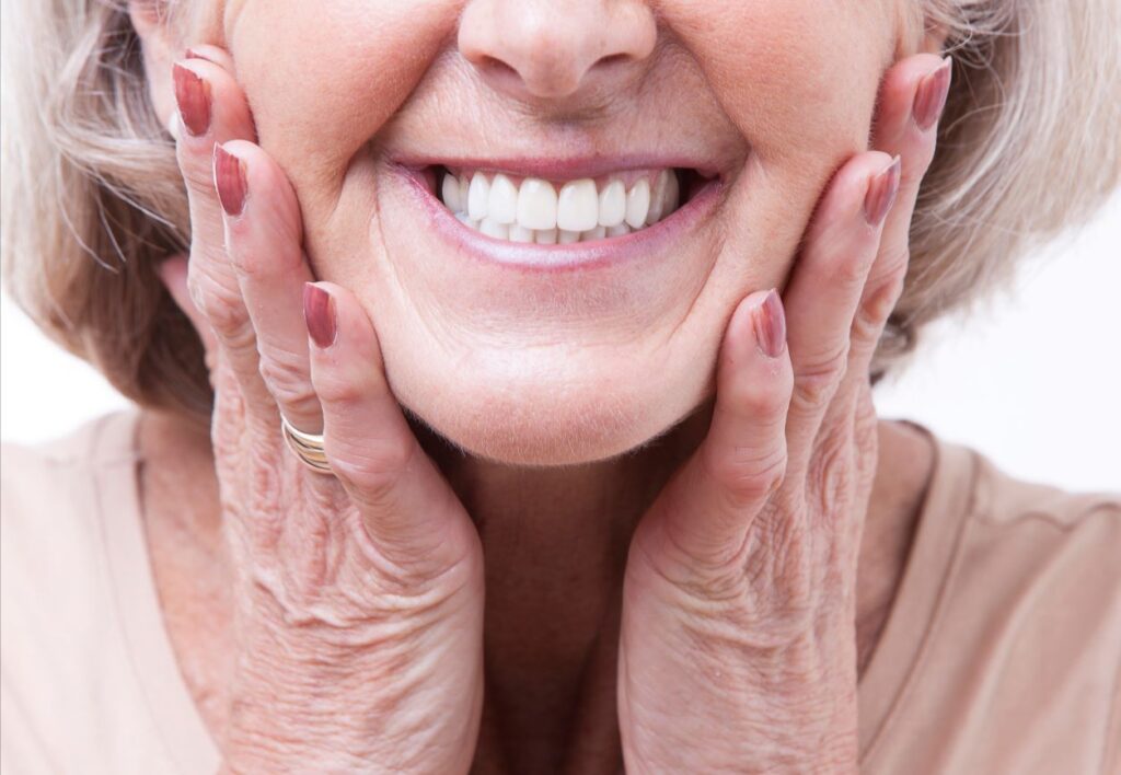 A woman smiling in her new dentures